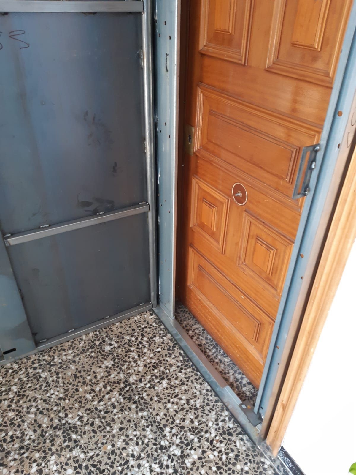 Un hombre con gafas está trabajando en una puerta.