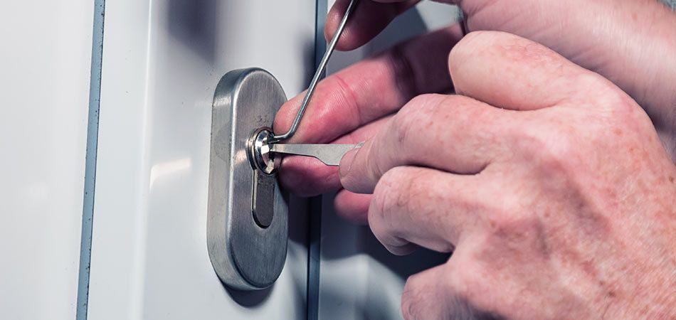 Un hombre está arreglando una puerta con un destornillador.