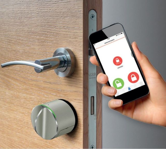 Una persona sostiene un teléfono inteligente frente a una puerta.
