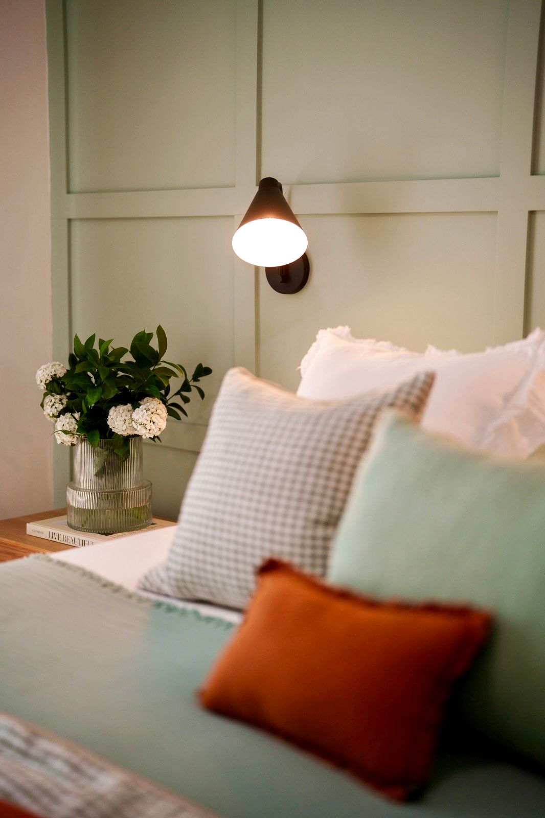 Sala de estar con sofá azul, mesa de centro de madera, sillones grises y estantería.