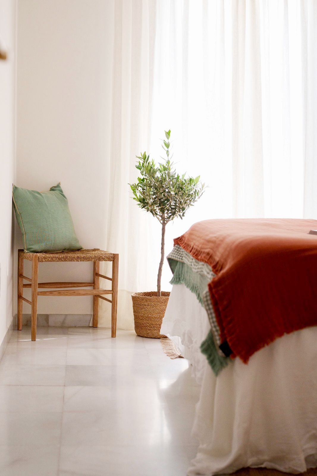 Pequeño tocador con pared decorativa de azulejos estampados, estante flotante de madera con lavabo y espejo redondo.