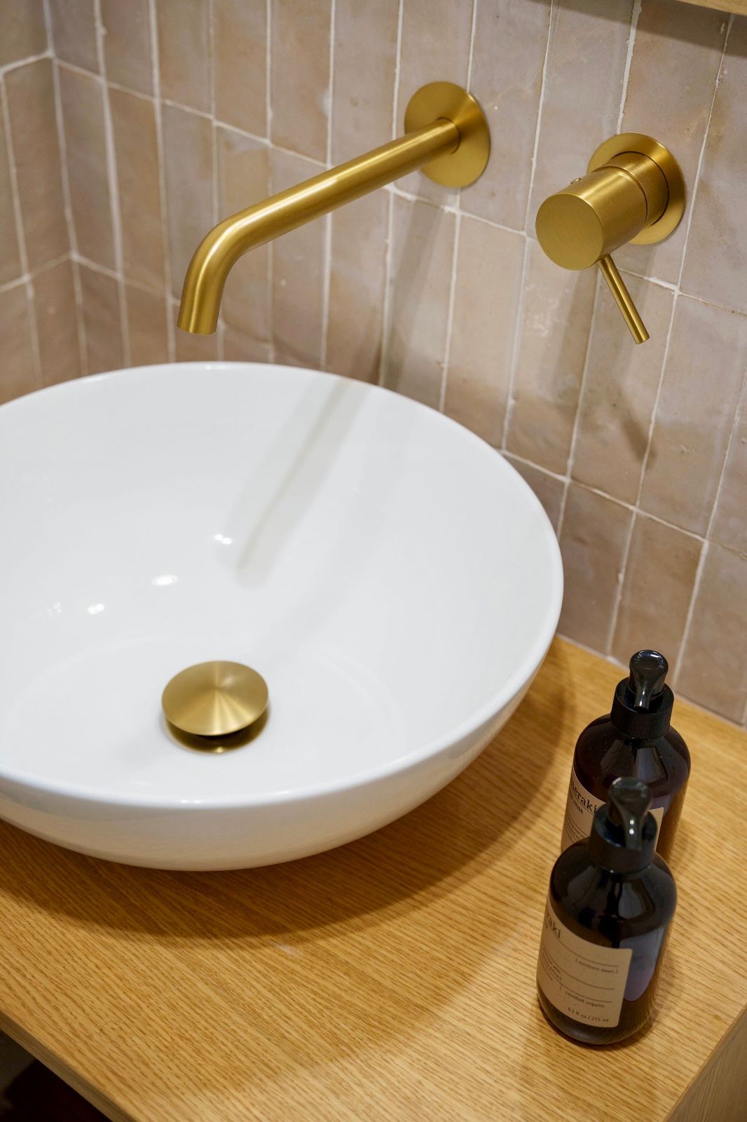 Baño con ducha, tocador, azulejos estampados, paredes amarillas, suelos de madera.