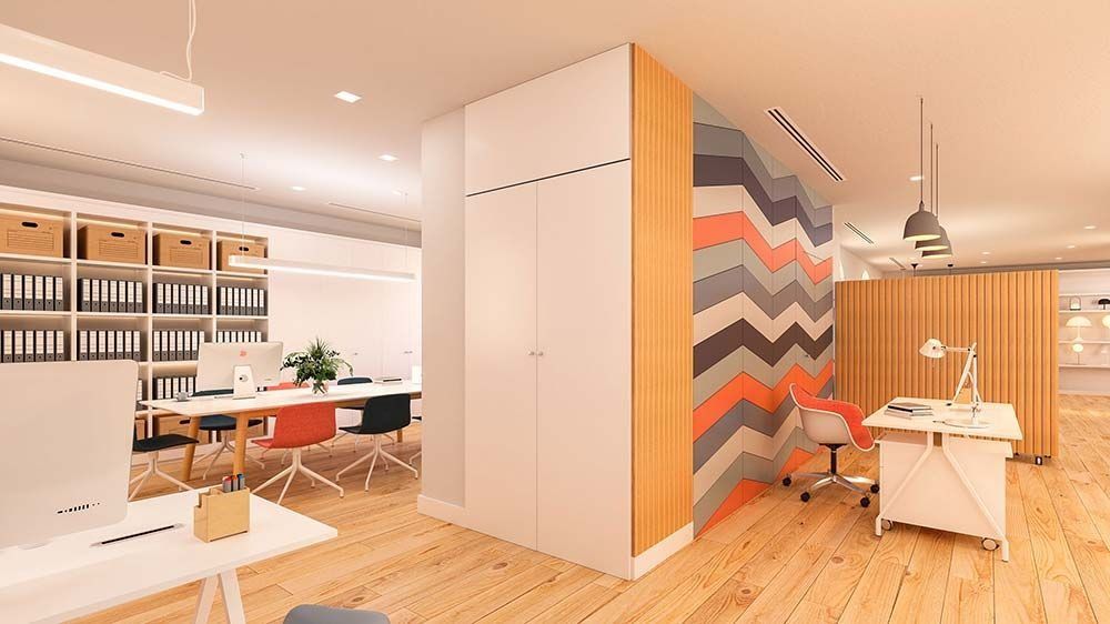 Interior de oficina moderna con suelos de madera, escritorios y espacio de almacenamiento. Pared con diseño de chevron.