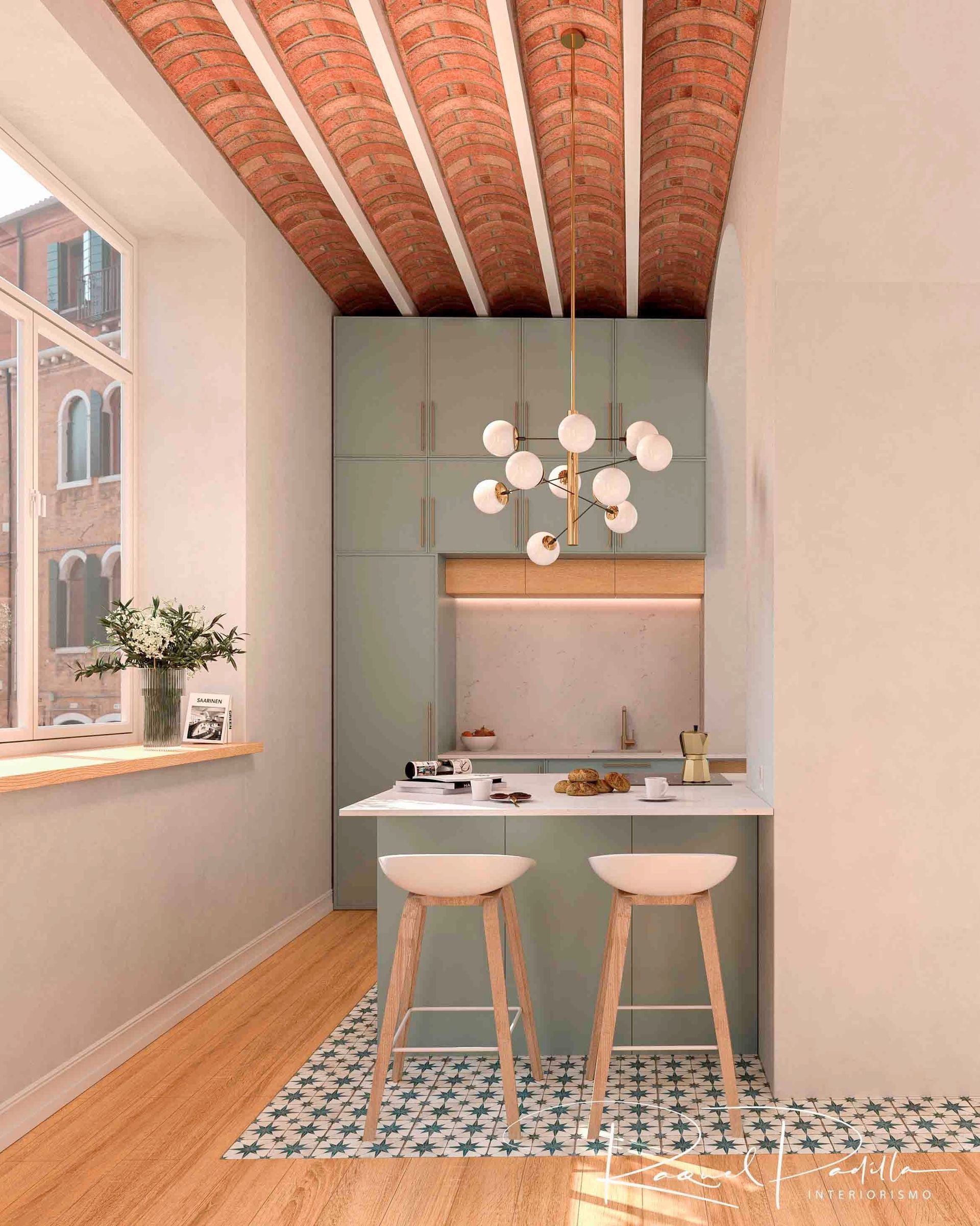 Cocina pequeña y moderna con gabinetes verdes, techo de ladrillo y una pequeña encimera con taburetes.