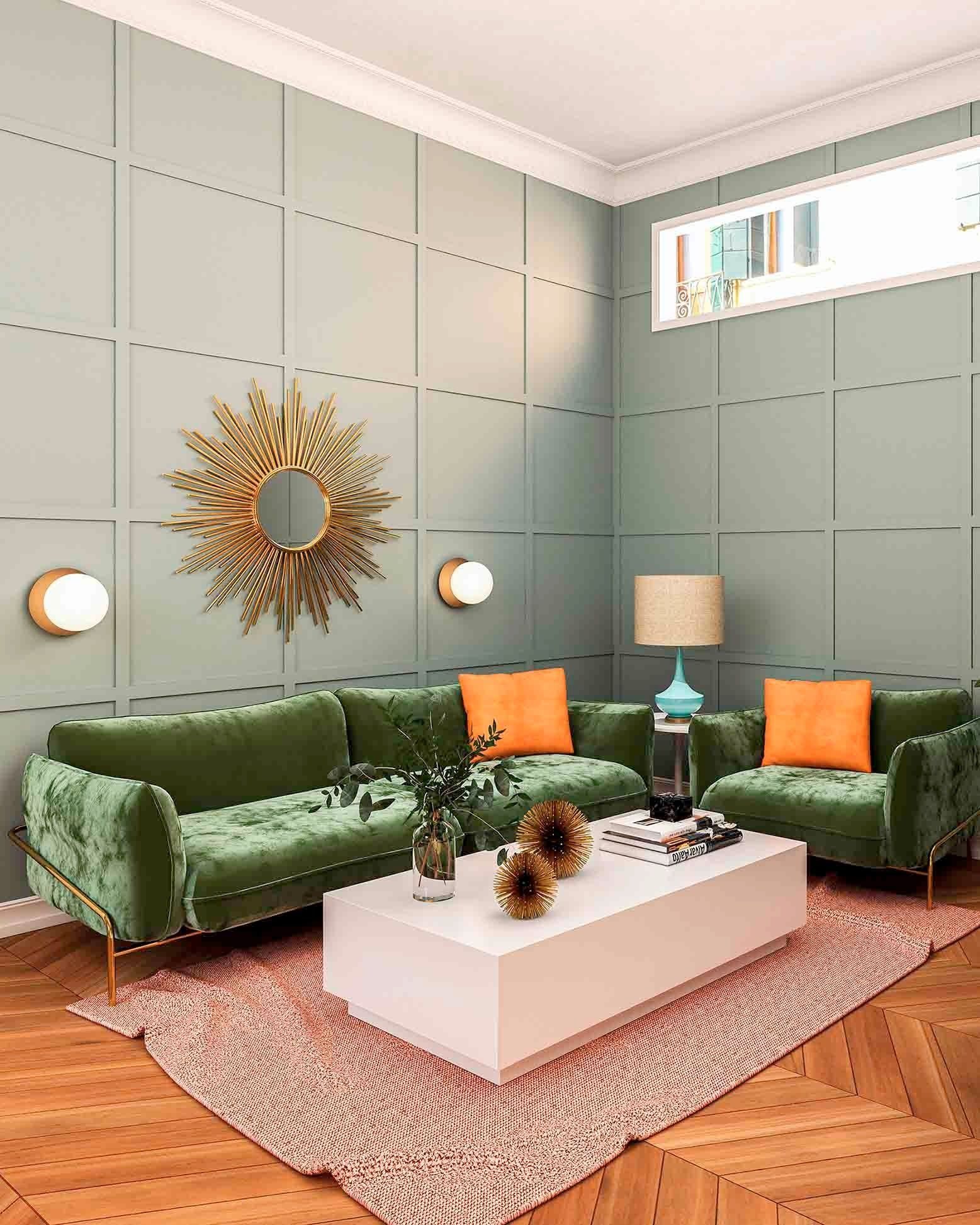 Sala de estar con sofá de terciopelo verde, almohadas naranjas y espejo con forma de estrella sobre paredes de paneles de color verde pálido.