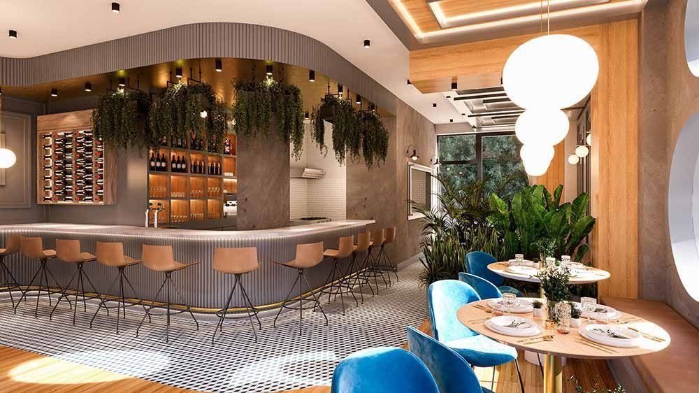 Interior de restaurante con barra curva, plantas colgantes, mesas con sillas azules y grandes lámparas redondas.