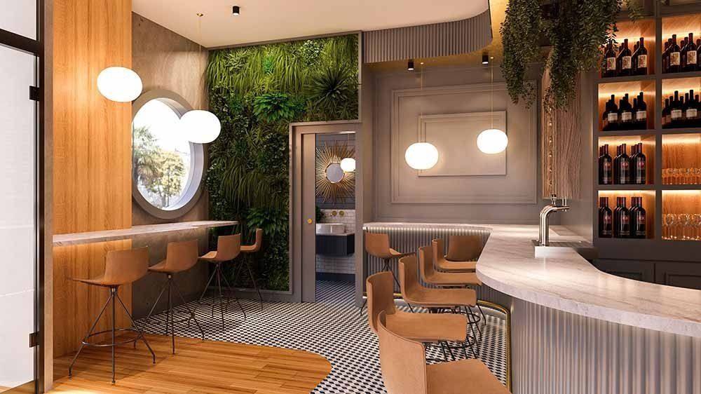 Interior de bar con taburetes, ventana circular y una pared de plantas.