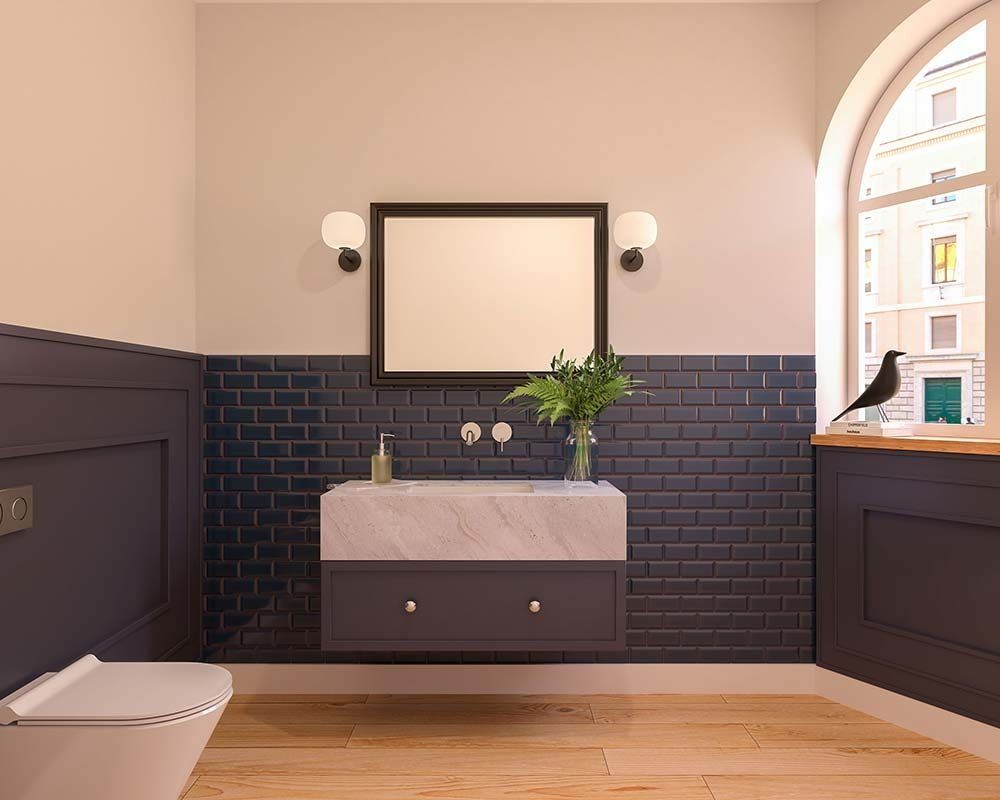 Baño con azulejos azules, tocador de mármol y ventana con vista a la calle.