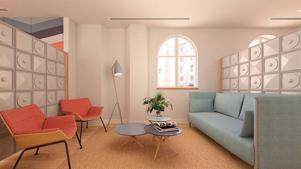 Moderna sala de espera con sofá azul, sillas de coral, paredes estampadas y ventana arqueada.