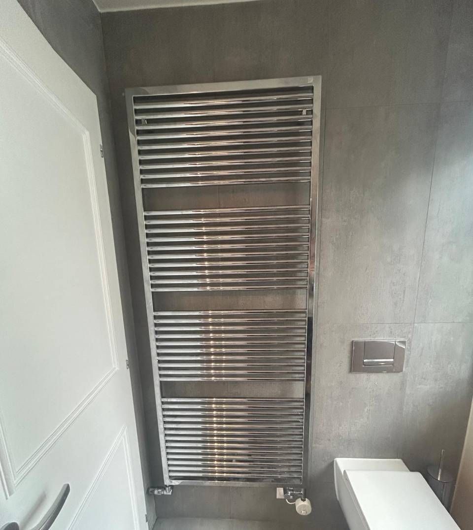 Un plombier répare un chauffe-eau avec une clé.