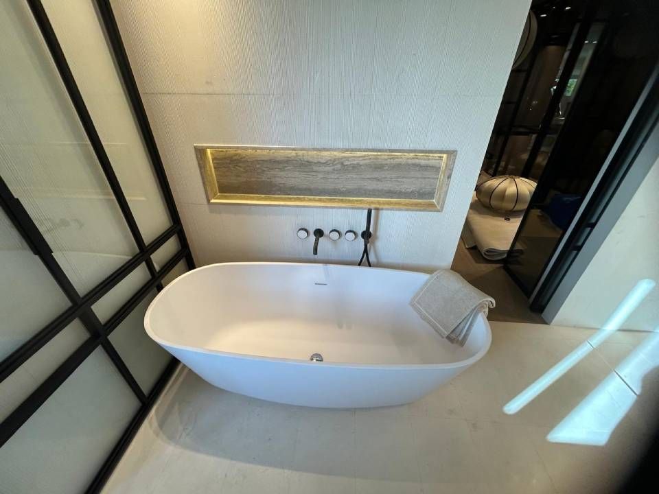 Une personne répare un tuyau d'évier avec une clé.