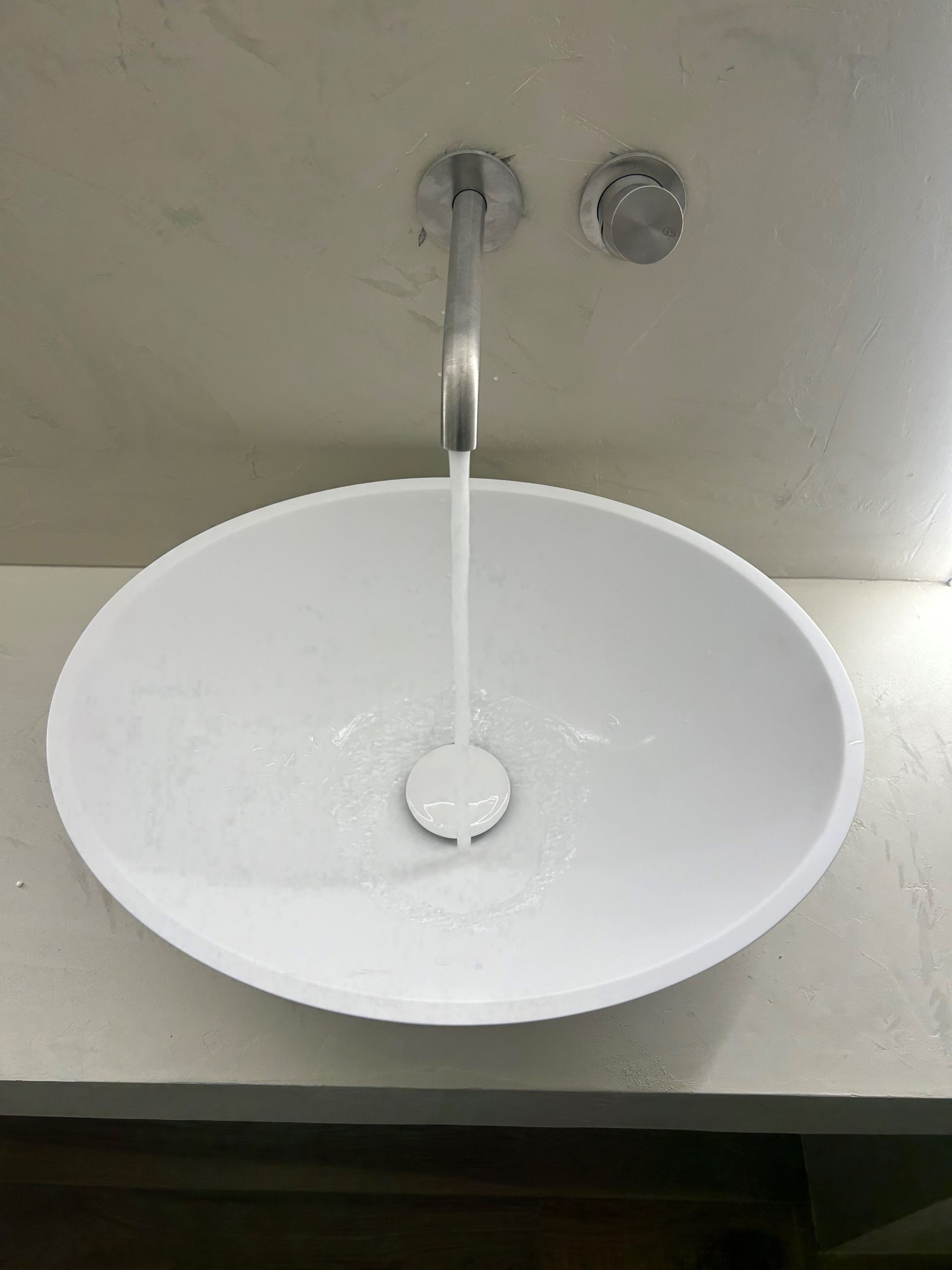 Un plombier travaille sur un tuyau avec une clé.