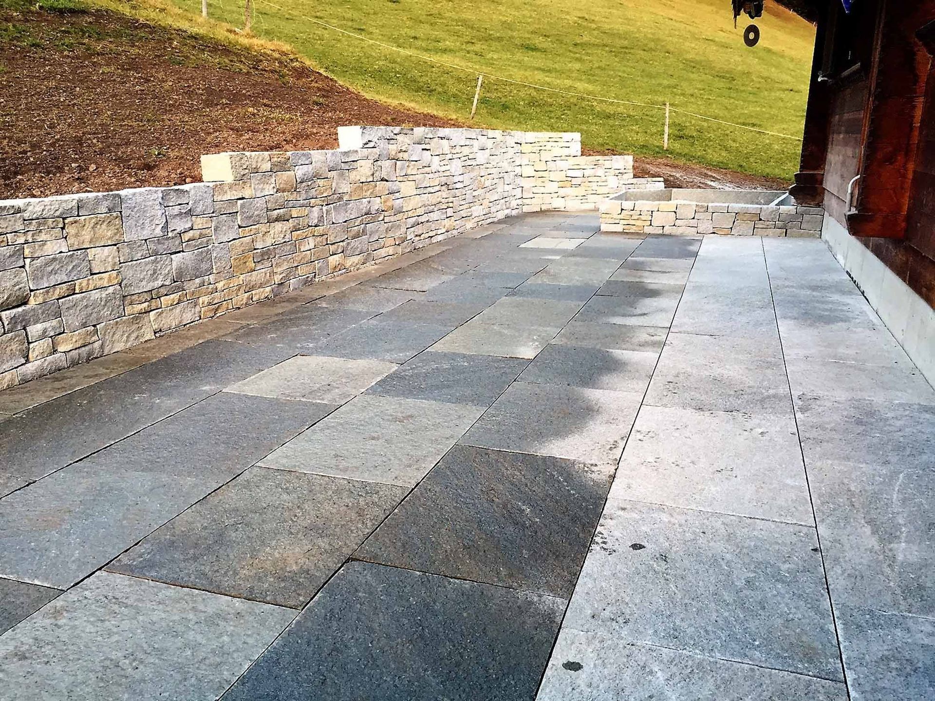 Natursteinplatten mit Stützmauer - Bowee Gartenbau AG