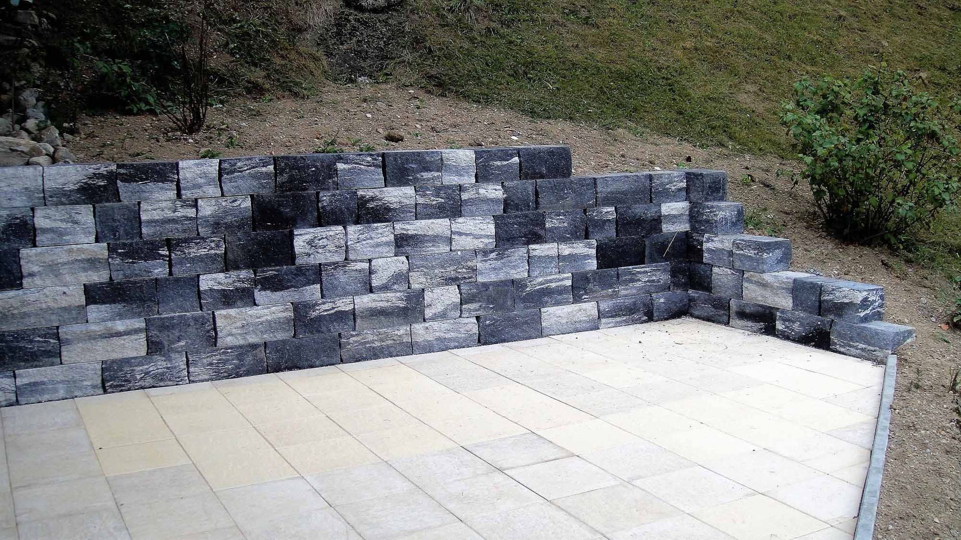 Stützmauer mit Bodenplattenbelag - Bowee Gartenbau AG