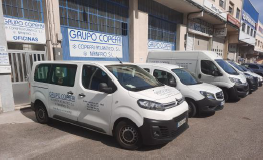 Una fila de furgonetas blancas estacionadas frente a un edificio.