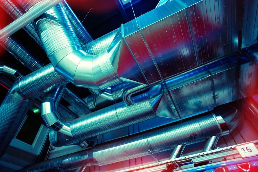 Un montón de tubos cuelgan del techo de un edificio.