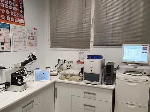 Un laboratorio con microscopio, computadora e impresora