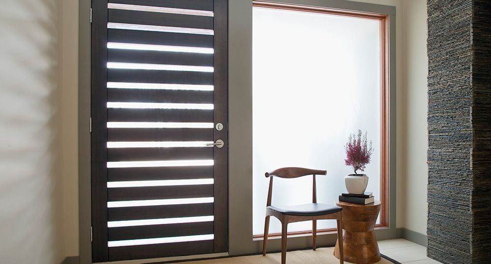 Porte moderne en bois avec lattes horizontales à côté d'une fenêtre dépolie et d'un petit tabouret en bois avec une chaise.