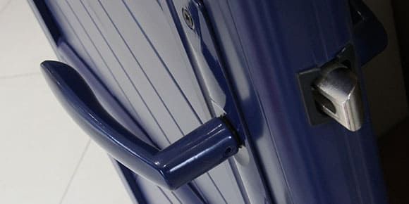 Porte bleue avec poignée et serrure argentées.