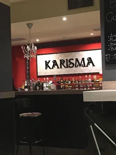 Interior de restaurante con una mesa puesta para los comensales y un gran botellero en la pared.