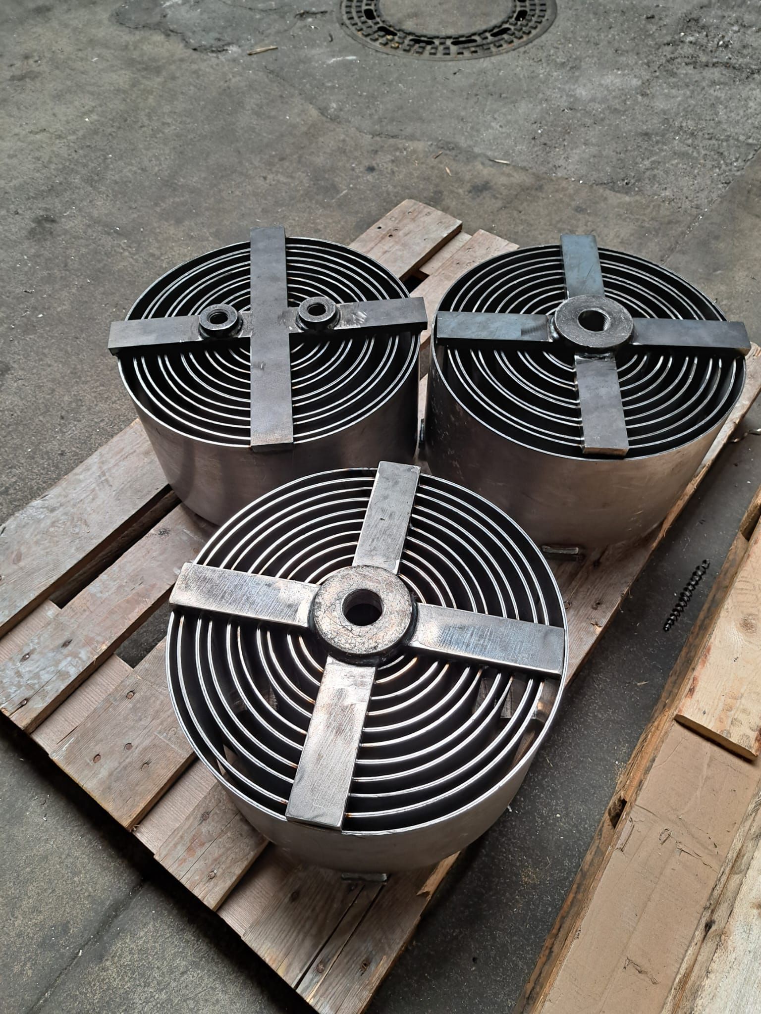 Auf einer Holzpalette sitzen drei Metallräder.