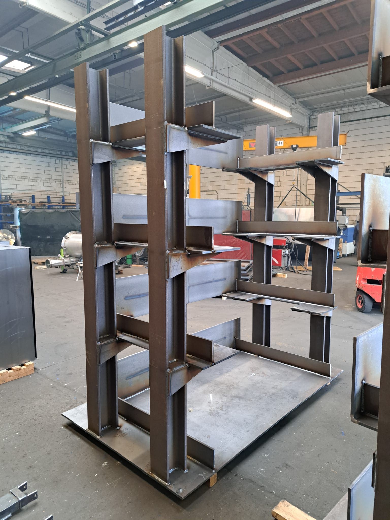 In einem Lagerhaus steht neben einem Gabelstapler ein Metallregal.