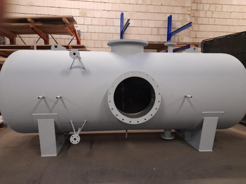 In einer Lagerhalle steht ein großer weißer Tank mit einem Loch in der Mitte. Petri Metall- & Apparatebau GmbH