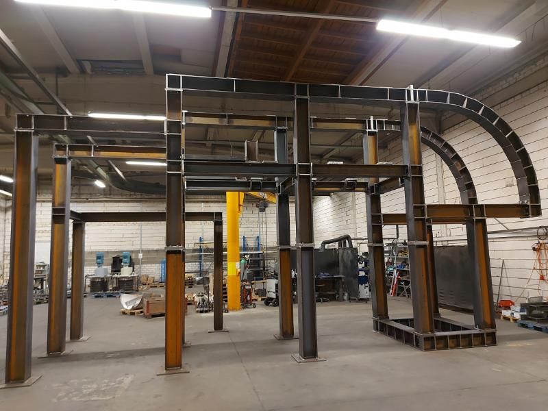 In einem Lagerhaus wird eine große Metallkonstruktion errichtet