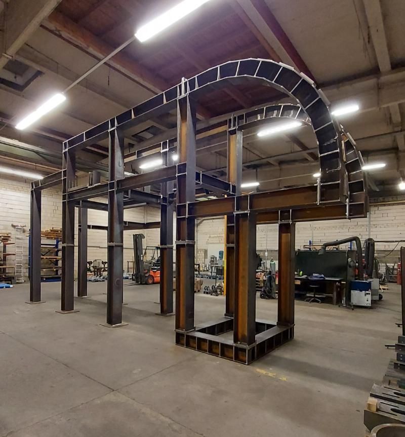 In einem Lagerhaus wird eine große Metallkonstruktion errichtet