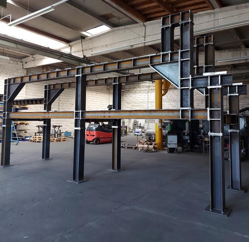 Eine große Metallkonstruktion in einem Lagerhaus mit einem Gabelstapler im Hintergrund