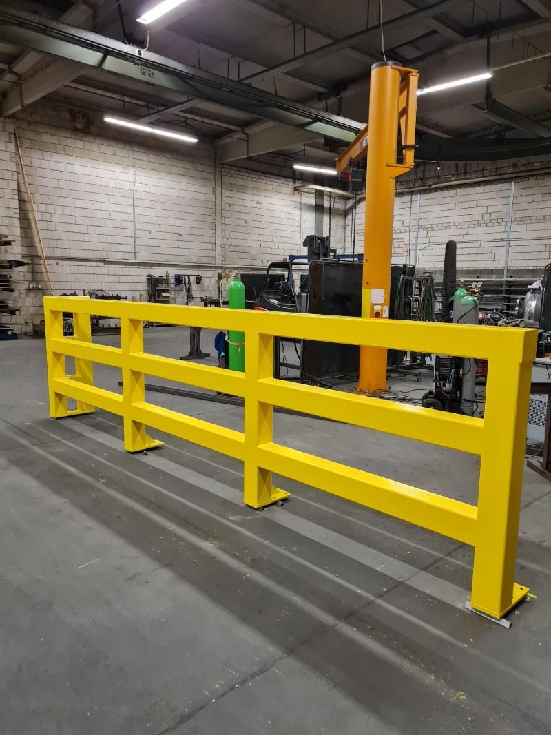 Ein gelber Zaun in einem Lagerhaus mit einem Gabelstapler im Hintergrund, Petri Metall- & Apparatebau GmbH