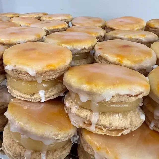 Un montón de sándwiches están apilados uno encima del otro sobre una mesa.