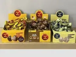 Tres cajas de dulces están encima de una mesa de madera.