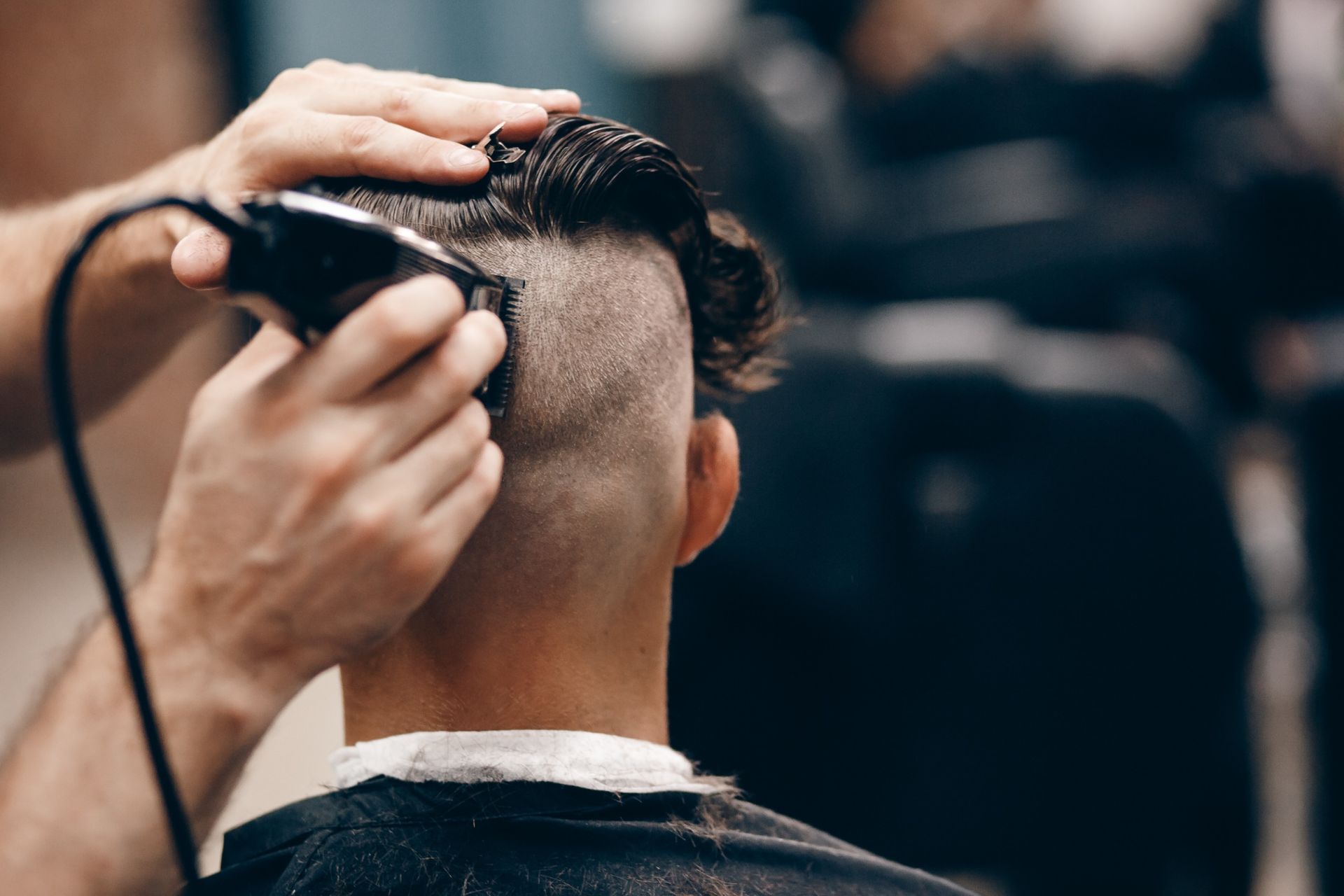 Un hombre se está cortando el pelo con una máquina barbera.