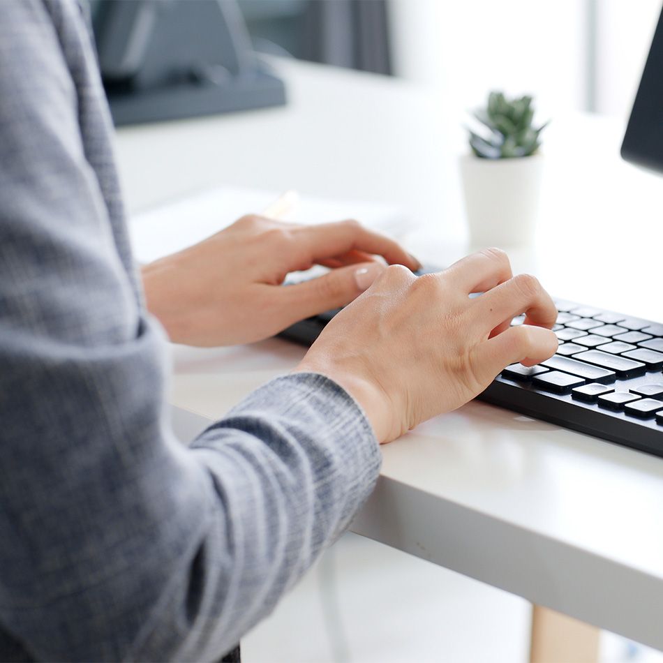 Mains posées sur un clavier d'ordinateur