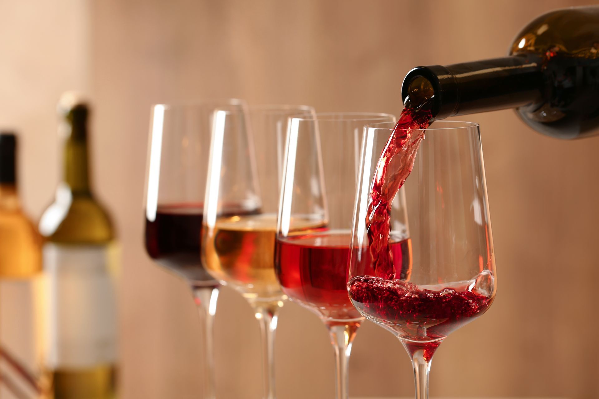 Du vin est versé dans plusieurs verres à vin sur une table.