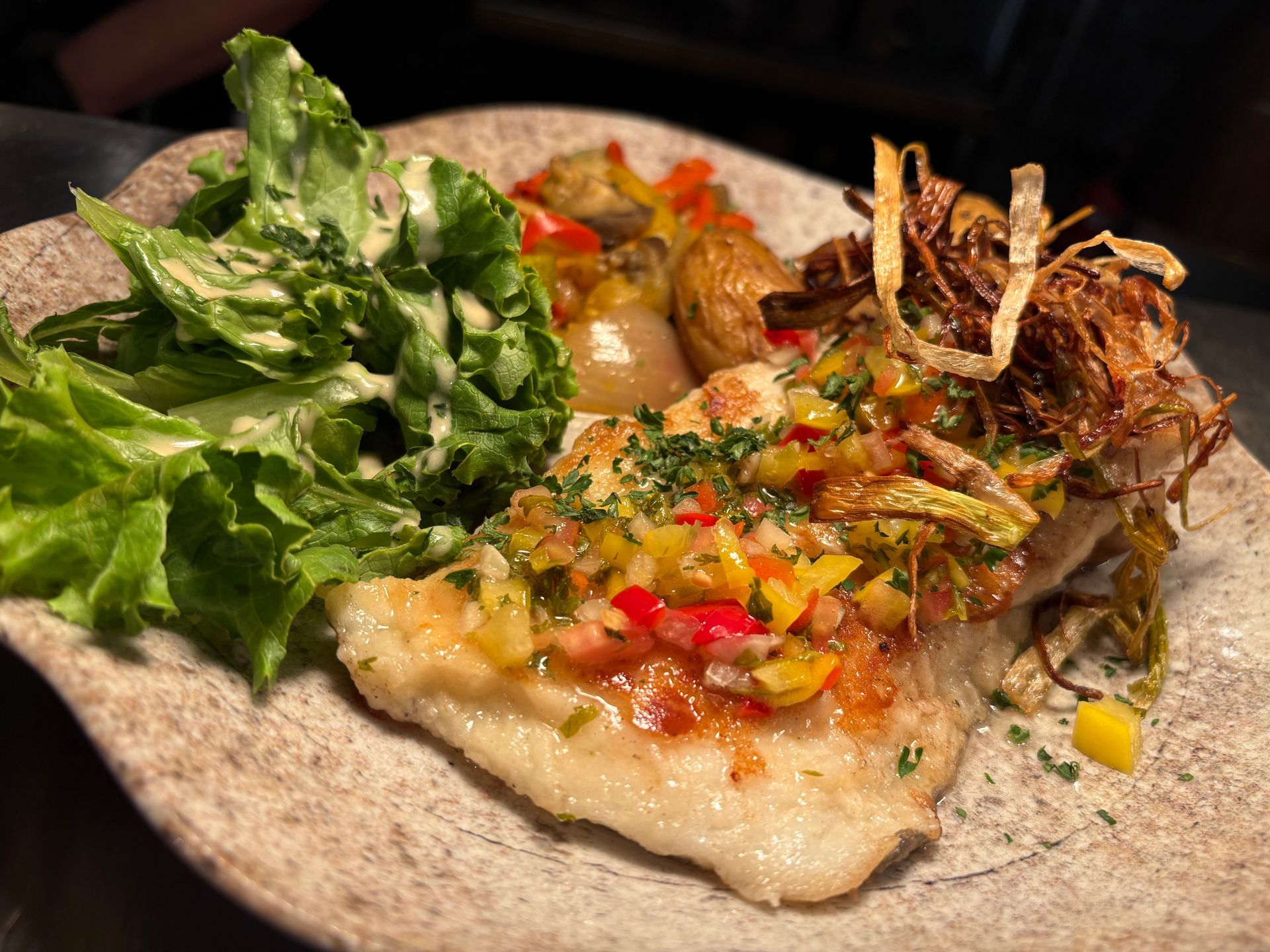 Poisson grillé avec des légumes sur une tortilla dans une assiette.