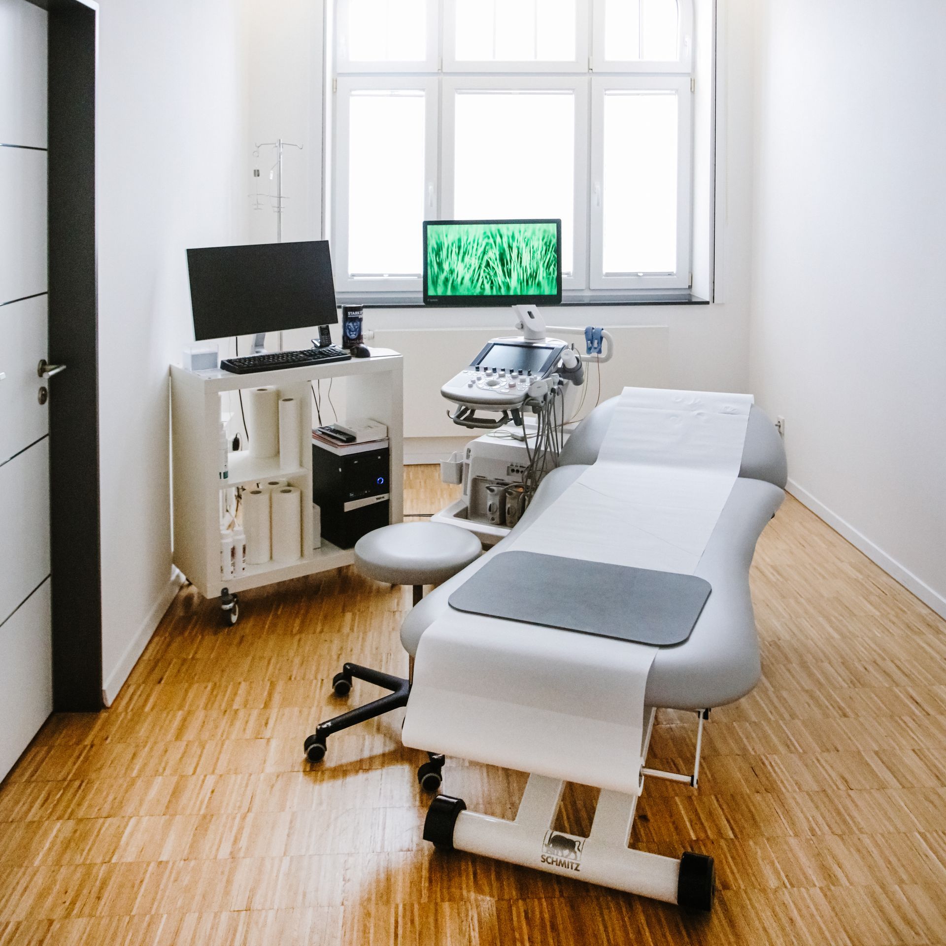 Eine Arztpraxis mit einem großen weißen Tisch und vielen medizinischen Geräten. Dr. med. Claus-Peter Pack