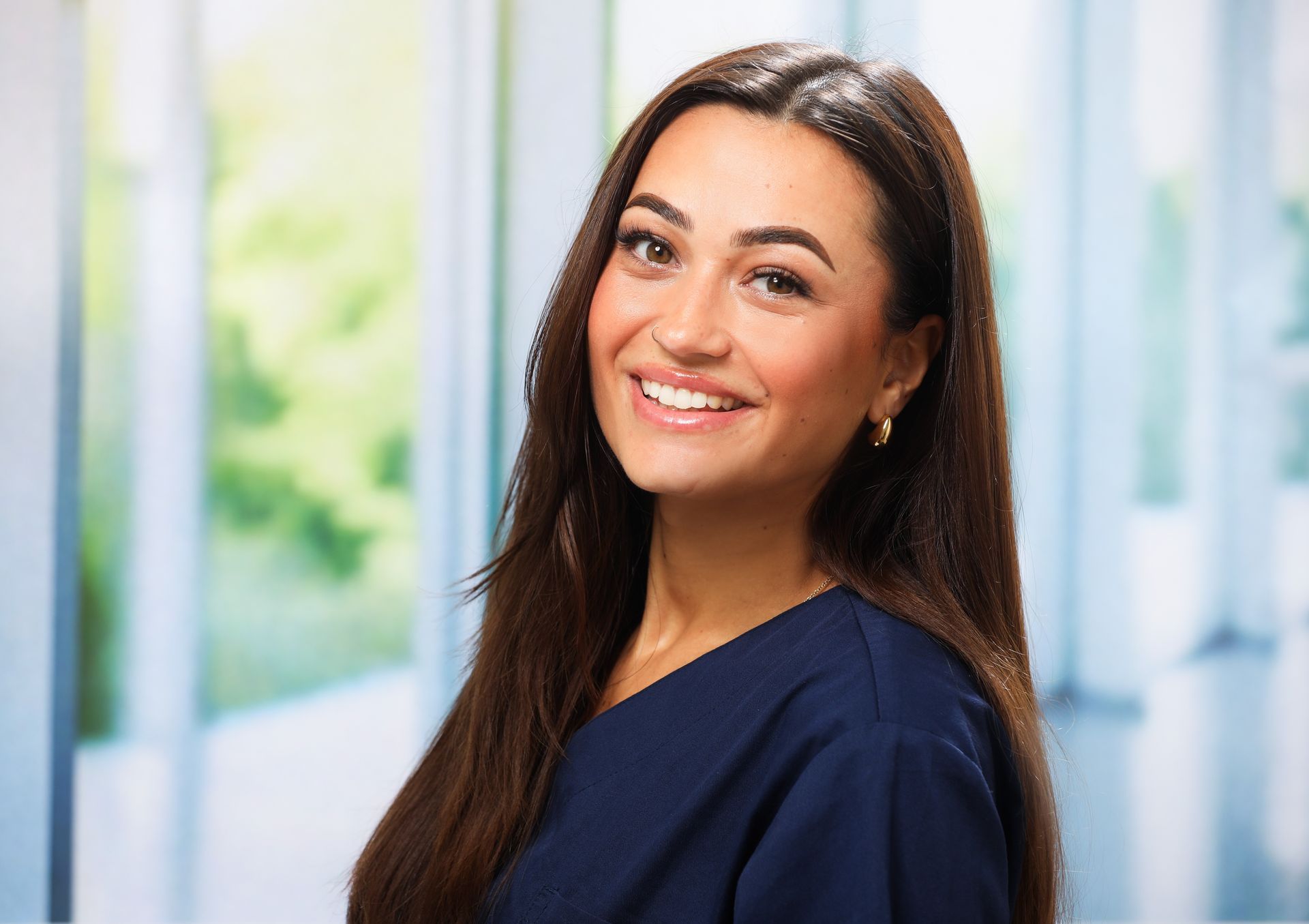 Eine Frau mit langen braunen Haaren lächelt in die Kamera.