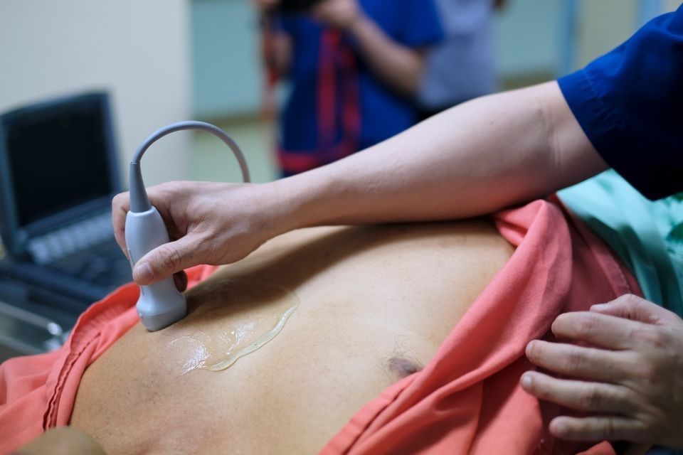 Bei einer Person wird eine Ultraschalluntersuchung des Bauches durchgeführt.