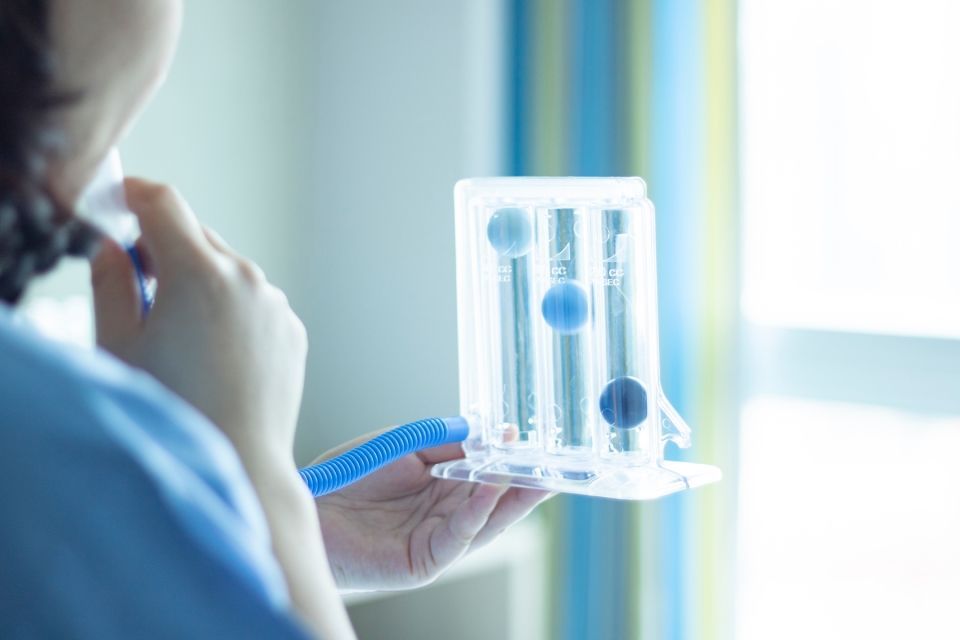 Eine Krankenschwester hält ein Beatmungsgerät in ihren Händen.