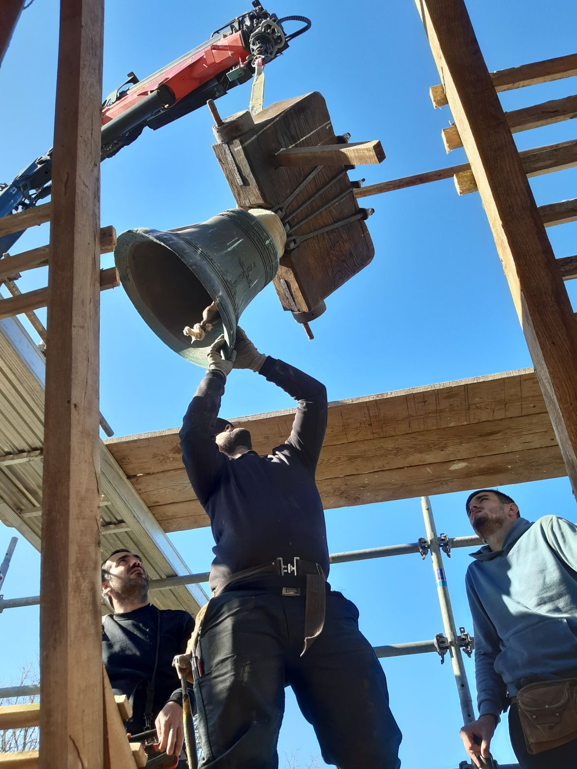 Photo de plusieurs artisans réalisant les travaux de réfection d'un clocher.