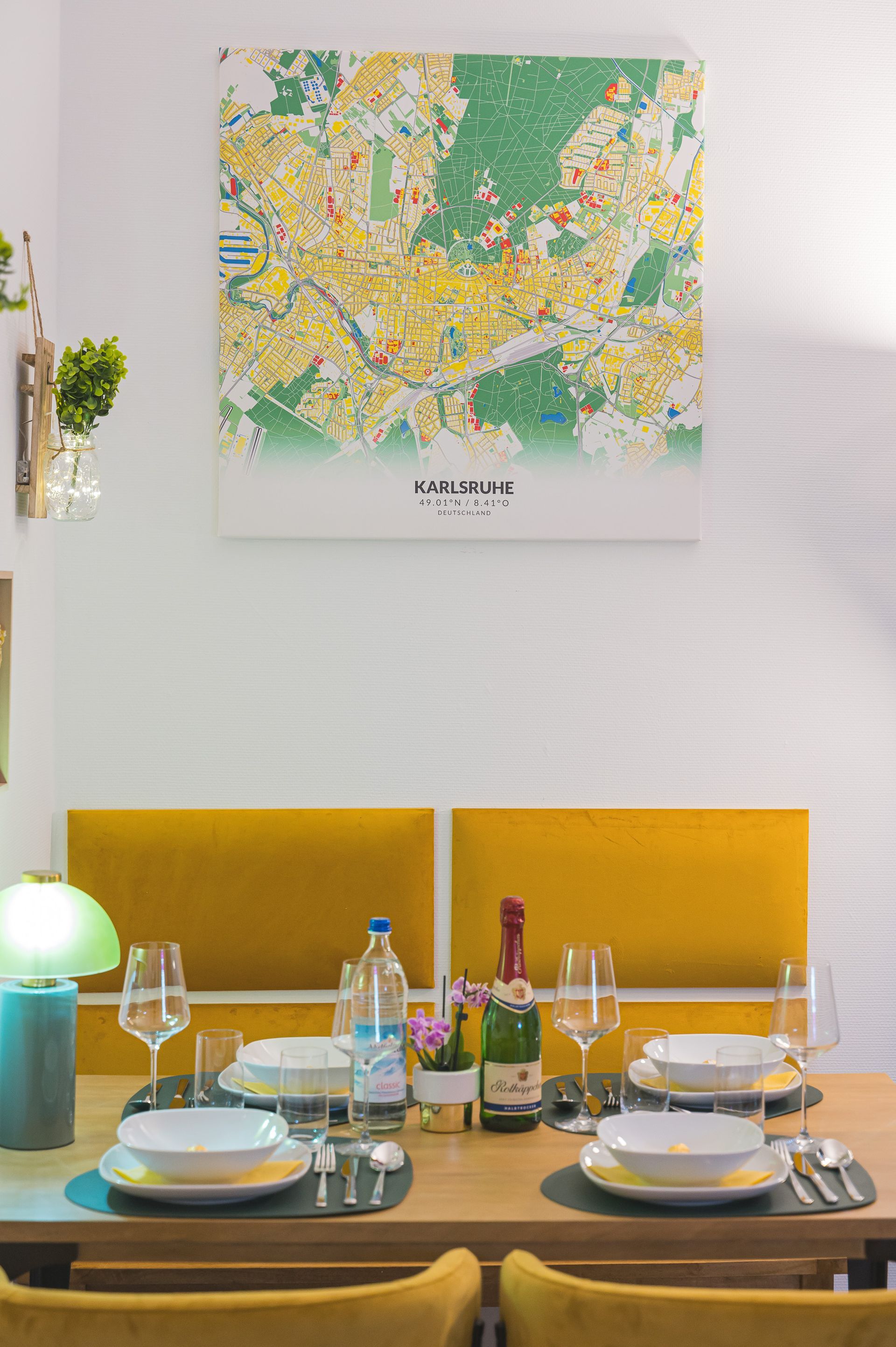 Dining table set for a meal with map art on the wall and yellow accents.