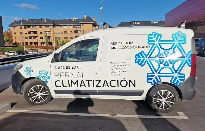 Una camioneta blanca con un copo de nieve en el costado está estacionada en un estacionamiento.
