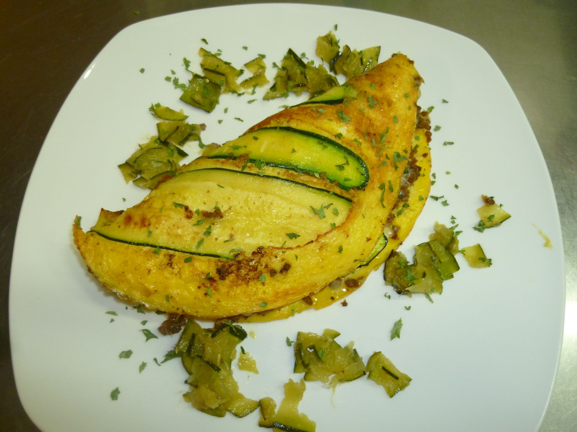 Ein weisser Teller mit Omelett und Gemüse