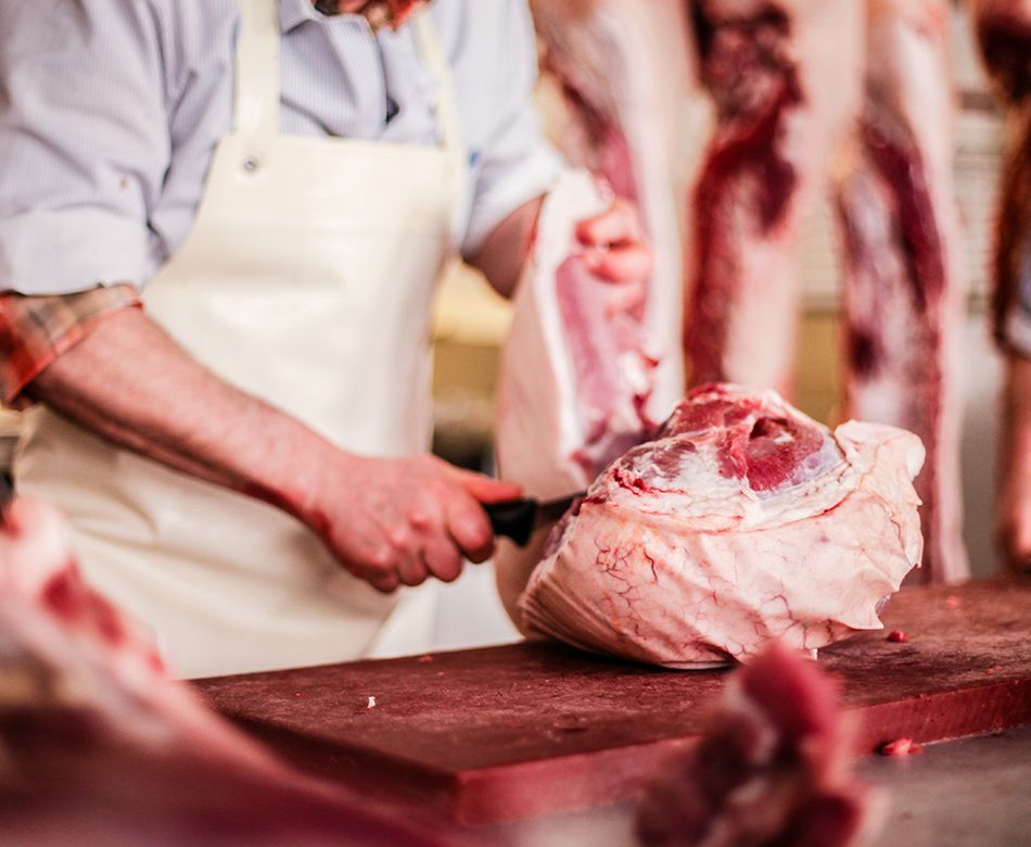 Boucher découpant une pièce de viande à l'aide d'un couteau