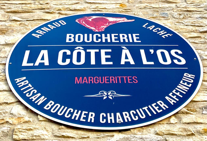 Logo La Boucherie La Côte À L’os sur plaque avec fond bleu