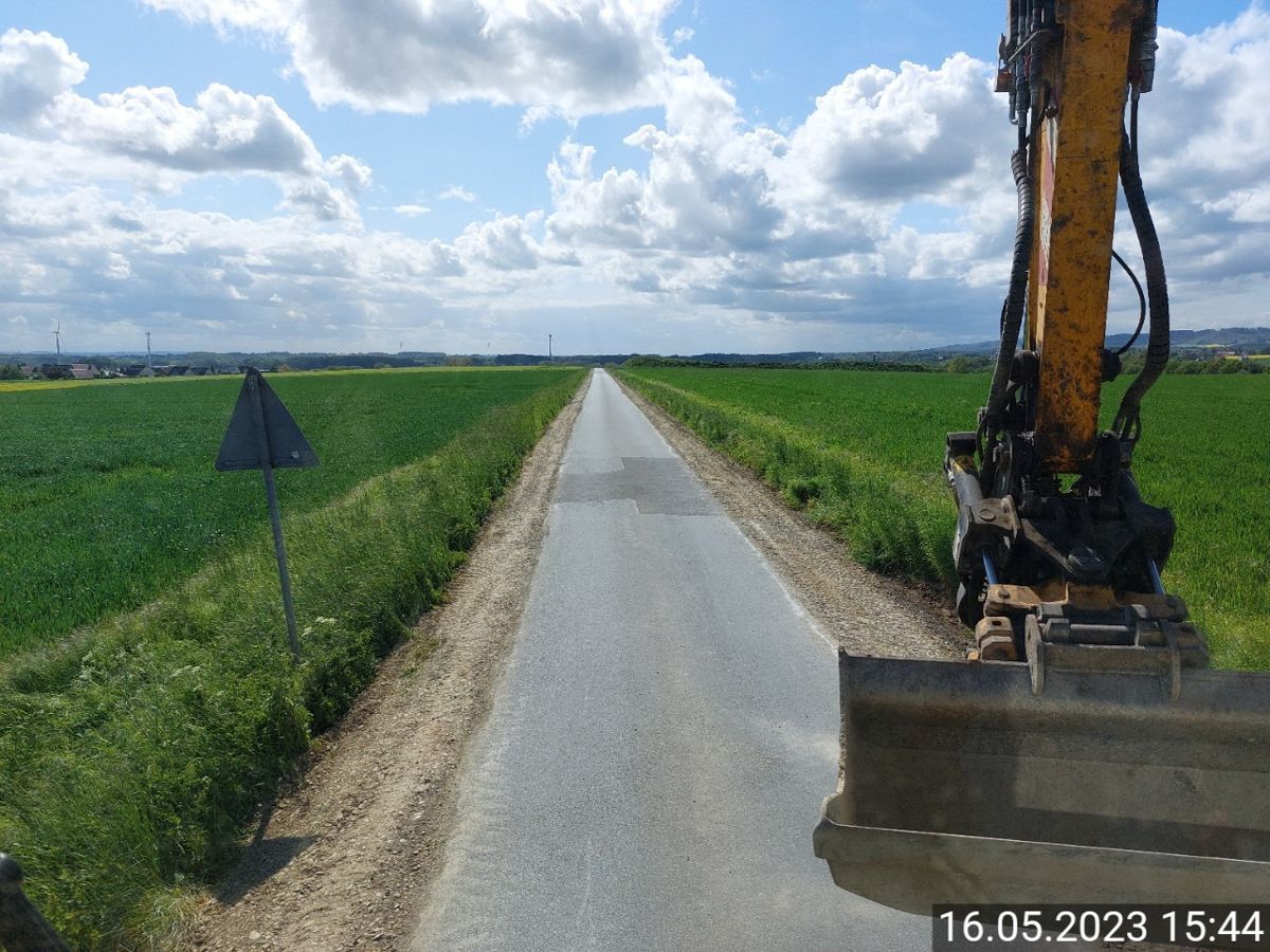 Ein Baufahrzeug fährt eine Straße auf einem Feld entlang