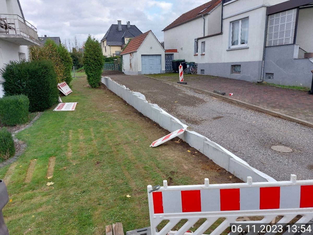 Am Straßenrand steht eine rot-weiße Barriere.