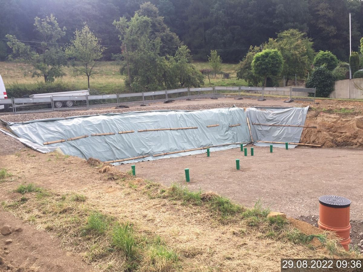 Inmitten eines Feldes wird ein großer Pool gebaut.